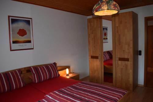 1 dormitorio con 1 cama con puerta de madera y espejo en Ferienwohnung Kagerbauer Christiane, en Lindberg