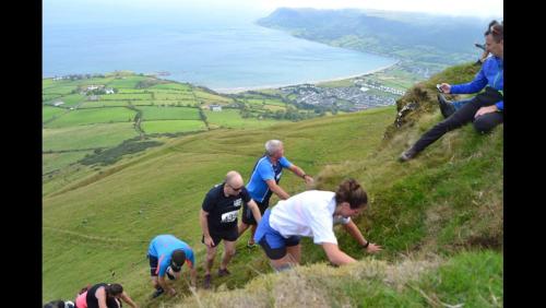 a group of people climbing up a hill at Killoughagh House in Cushendall