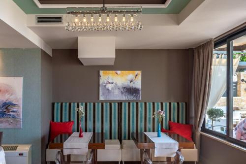 a dining room with two tables and a chandelier at Alexis Hotel in Chania Town