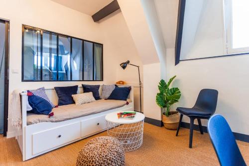 un salon avec un canapé et une chaise dans l'établissement Greeter-Bel appartement au pied des falaises d'Etretat, à Étretat