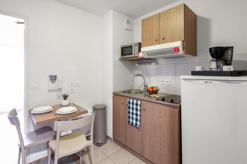 a small kitchen with a small table and a sink at Appart'City Niort in Niort