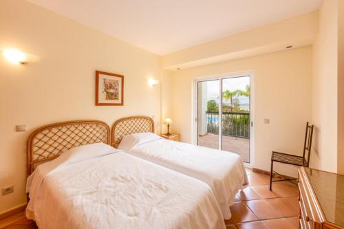 two beds in a bedroom with a view of the ocean at Clube Alvor Ria - Prime Residence in Alvor