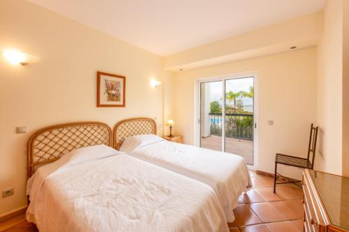 Dos camas en un dormitorio con vista al mar. en Clube Alvor Ria - Prime Residence, en Alvor