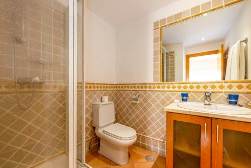 Un baño con inodoro, lavabo y ducha. en Clube Alvor Ria - Prime Residence, en Alvor