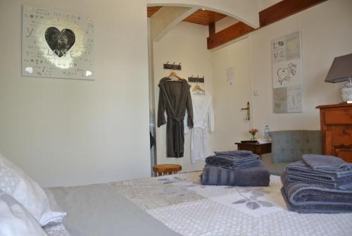 Chez Michel et Josette في Le May-sur-Èvre: غرفة نوم مع سرير وملابس معلقة على الحائط