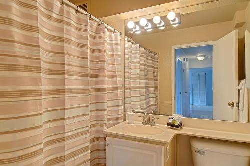 a bathroom with a sink and a shower curtain at Hubble Place Condos in Seattle