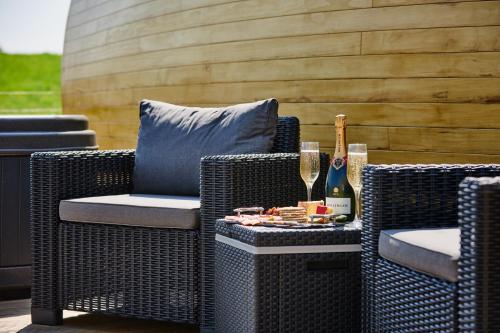 a patio with two wicker chairs and a bottle of champagne at Luxury Hideaways in Keilour
