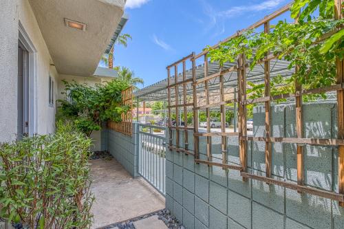 a building with a green wall with windows at Sordid Lives Condo Permit# 3202 in Palm Springs