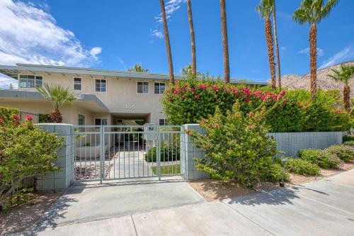 a house with a gate and palm trees at Sordid Lives Condo Permit# 3202 in Palm Springs