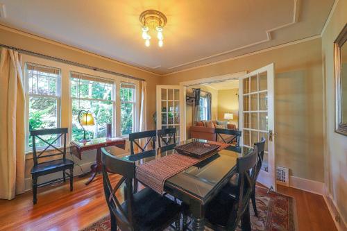 a dining room with a table and chairs and windows at Lakefront Craftsman in Seattle