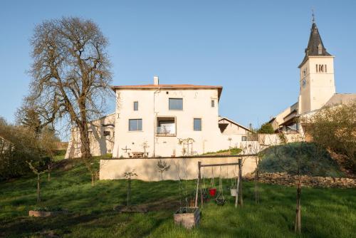 une vieille maison sur une colline avec une tour dans l'établissement La Maison Forte - chambres et table d'hôtes, à Millery