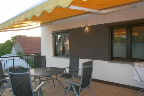 a patio with a table and chairs on a balcony at Villa Rynek in Góra Świętej Anny