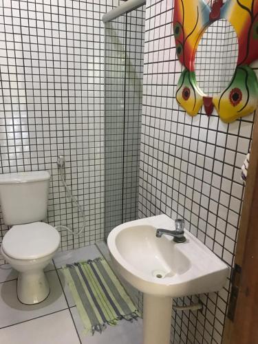 a bathroom with a toilet and a sink at Pousada Santa Bárbara in Maruda