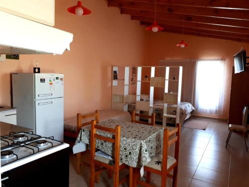a kitchen and dining room with a table and a refrigerator at Alem in Puerto Madryn