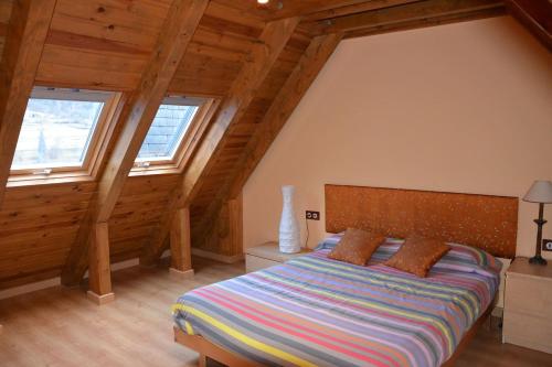 ein Schlafzimmer mit einem Bett in einem Zimmer mit Holzdecken in der Unterkunft Laurit in Bossost