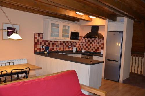 cocina con mesa y sofá rojo en una habitación en Laurit, en Bossòst
