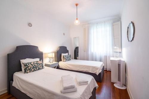 リスボンにあるAkicity Lisboa Star IIの小さなベッドルーム(ベッド2台、窓付)