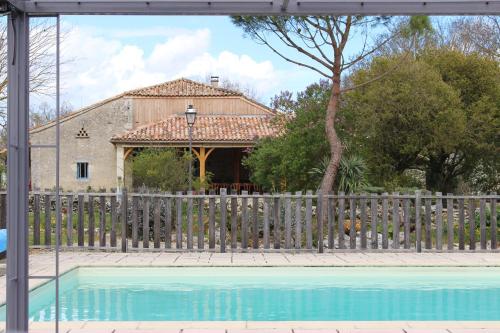 a house with a fence and a swimming pool at Le Vignal in Monflanquin