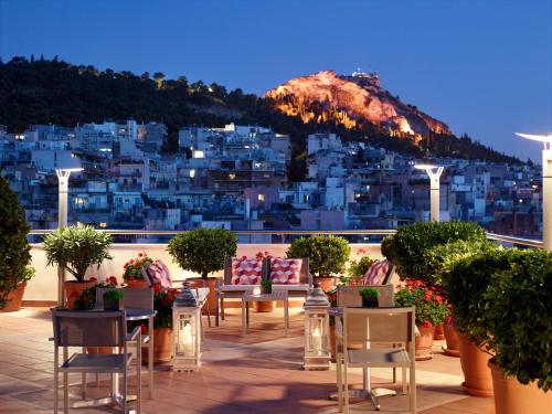 a patio with tables and chairs and a view of a city at Athens Zafolia Hotel in Athens