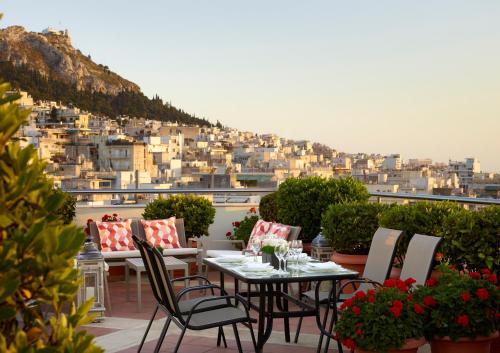a table and chairs on a balcony with a view at Athens Zafolia Hotel in Athens