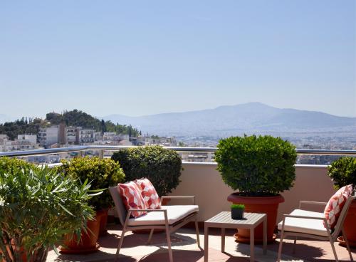 a balcony with chairs and a view of a city at Athens Zafolia Hotel in Athens