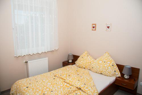 a bedroom with a bed with yellow sheets and pillows at Apartamenty Fala in Rowy