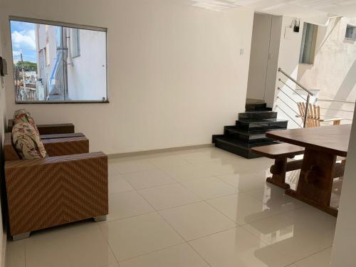 a living room with a chair and a table and stairs at Hotel Skalla - MELHOR CUSTO BENEFICIO in Teixeira de Freitas