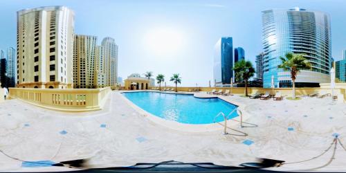 ein Schwimmbad mitten in einer Stadt mit hohen Gebäuden in der Unterkunft Magic waves holiday in Dubai