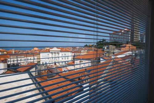 a view of a city from a window with blinds at Apartment Sebastijan in Piran