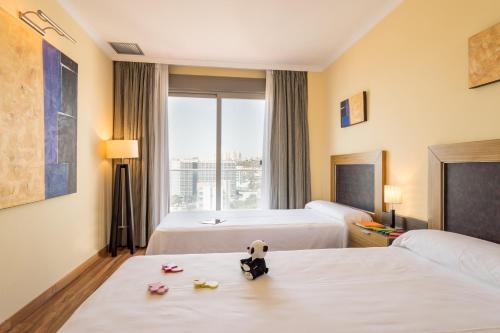 a hotel room with two beds with a panda doll on a table at Pierre & Vacances Benalmádena Príncipe in Benalmádena