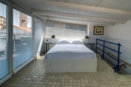 a bedroom with a bed in a room with windows at Apartment Sebastijan in Piran
