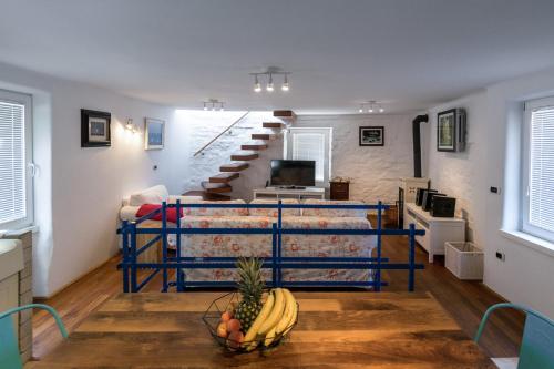 ein Wohnzimmer mit einer Treppe und Obst auf dem Tisch in der Unterkunft Apartment Sebastijan in Piran