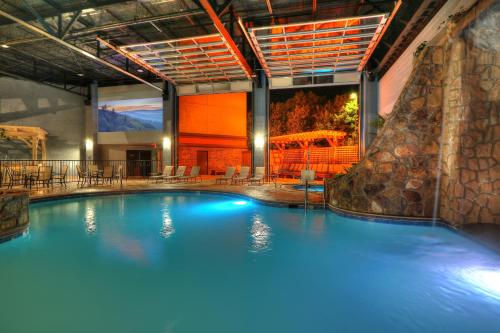 a large swimming pool with a slide in a building at The Ramsey Hotel and Convention Center in Pigeon Forge