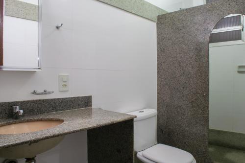 La salle de bains est pourvue d'un lavabo et de toilettes. dans l'établissement Hotel Rio Grande, à Cachoeiro de Itapemirim