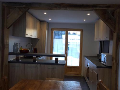 a kitchen with wooden cabinets and a table and a window at Chalet Les Contamines in Les Contamines-Montjoie