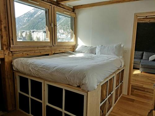 un lit dans une chambre avec une fenêtre dans l'établissement Beautiful apartment in Chamonix centre with superb mountain views, à Chamonix-Mont-Blanc
