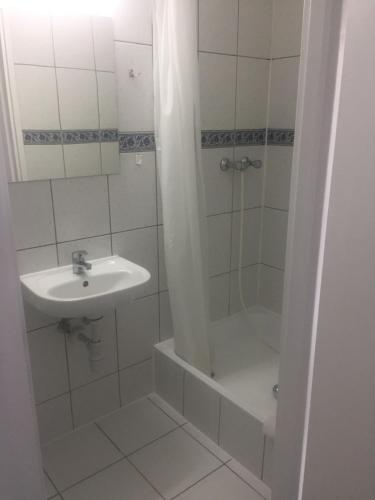 a white bathroom with a sink and a shower at Eden in Wisełka