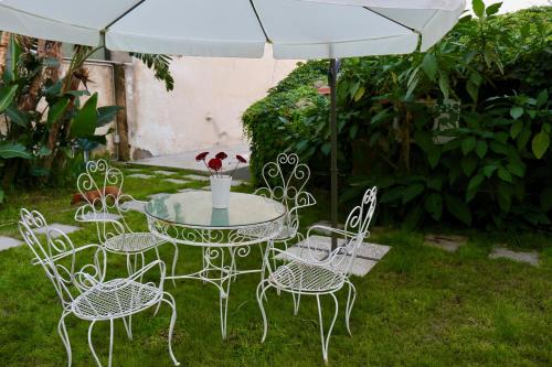 a table and chairs under an umbrella in a yard at Acquabianca in Aci Castello