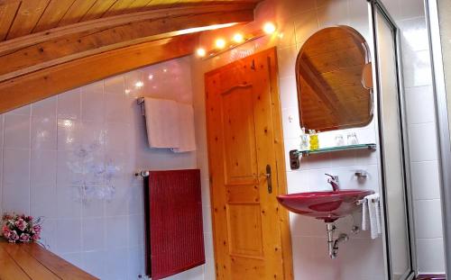 a bathroom with a red sink and a mirror at Feriendomizil St. Ulrich in Krün