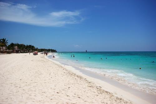 a group of people in the water on a beach at Palmar del Sol by Riviera Maya Suites in Playa del Carmen