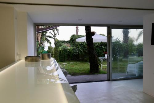 an open living room with a table and a sliding glass door at Acquabianca in Aci Castello