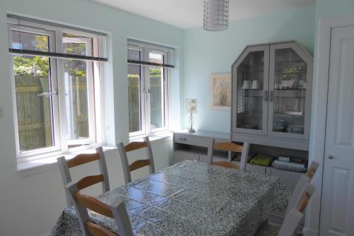 a dining room with a table and chairs and windows at Tom Morris Drive in Fife