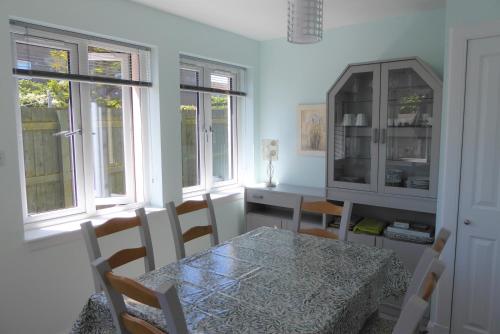 comedor con mesa, sillas y ventanas en Tom Morris Drive en Fife