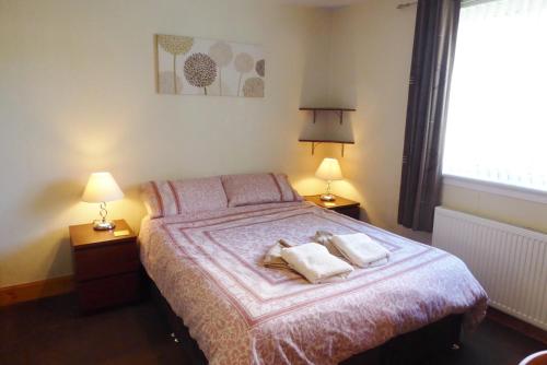 a bedroom with a bed with two pillows on it at Tom Morris Drive in Fife