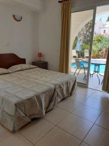 una camera con letto e vista sulla piscina di Arilena Holiday Apartments a Paphos