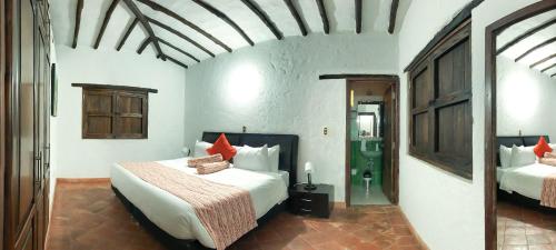 1 dormitorio con 2 camas y almohadas rojas en Hotel Majams Resort, en San Gil