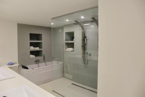 een badkamer met een douche, een bad en een wastafel bij Acquabianca in Aci Castello