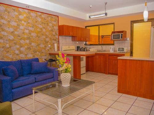 a living room with a blue couch and a table at Hotel Bamboo Aeropuerto in Alajuela City
