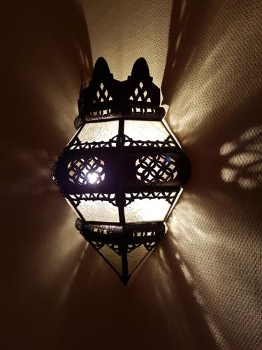 a light on the side of a wall at Hôtel du Centre in Lourdes