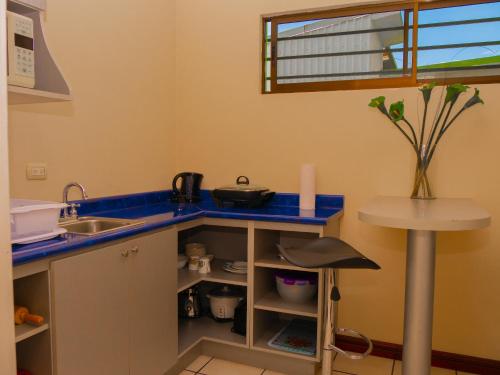 a kitchen with a blue counter top and a sink at Hotel Bamboo Aeropuerto in Alajuela City